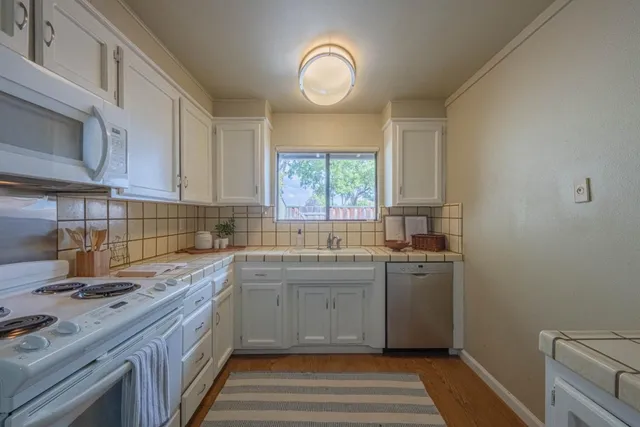 a kitchen with stainless steel appliances granite countertop a sink stove and cabinets