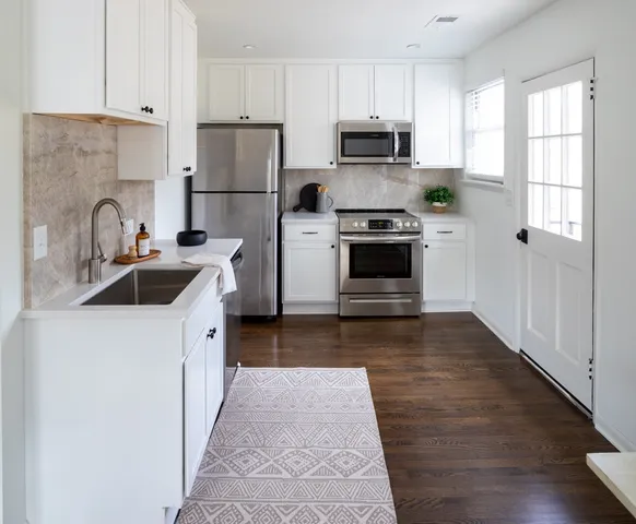 a kitchen with kitchen island a sink cabinets and stainless steel appliances