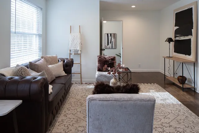 a living room with furniture a flat screen tv and a window