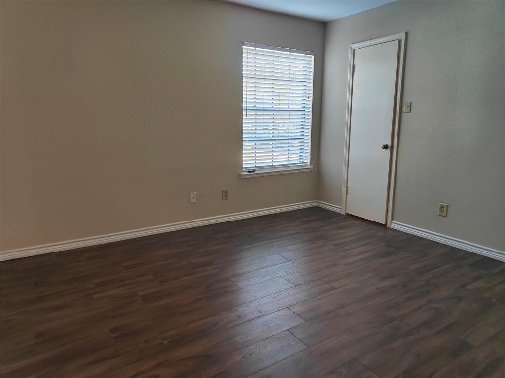 4748 Old Bent Tree Lane, Unit 207 Dallas, TX 75287 - Photo 11 of 20 an empty room with wooden floor and windows