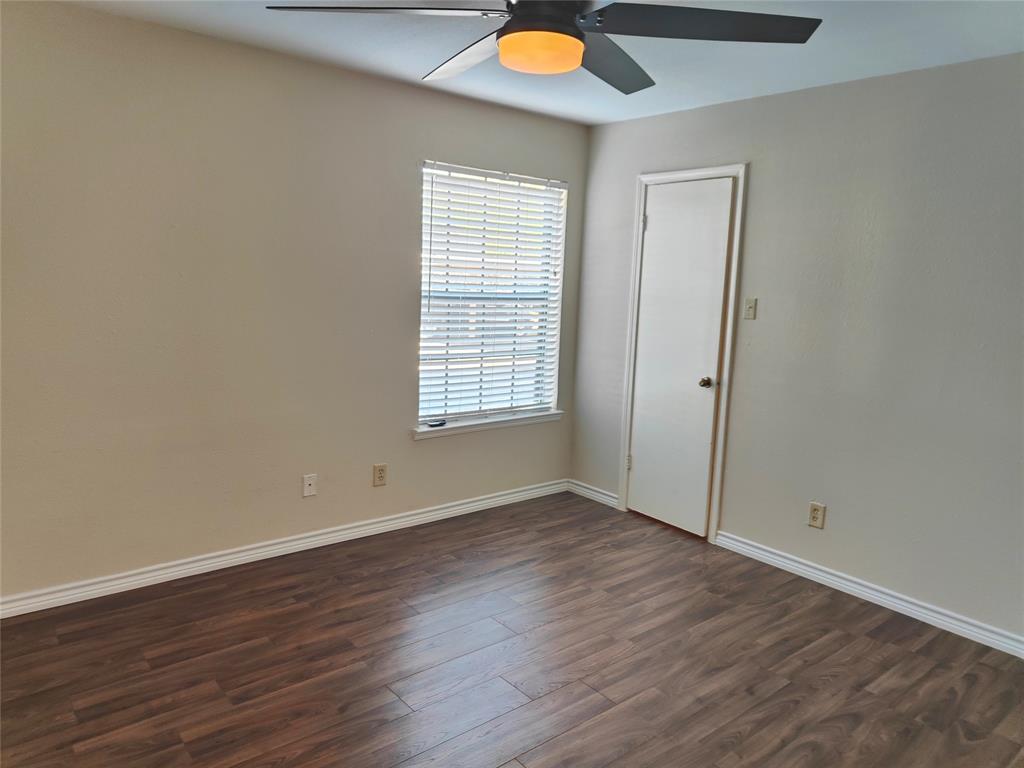 4748 Old Bent Tree Lane, Unit 207 Dallas, TX 75287 - Photo 12 of 20 an empty room with wooden floor and windows