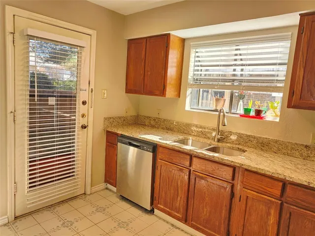 a kitchen with stainless steel appliances granite countertop a sink and a window