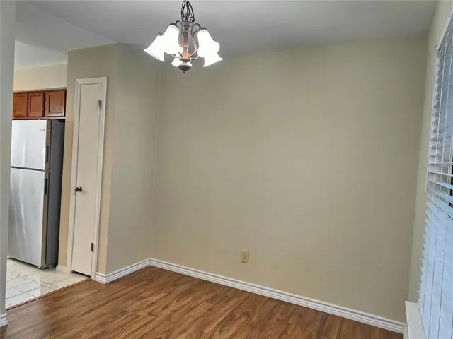 a view of a chandelier in big room and wooden floor