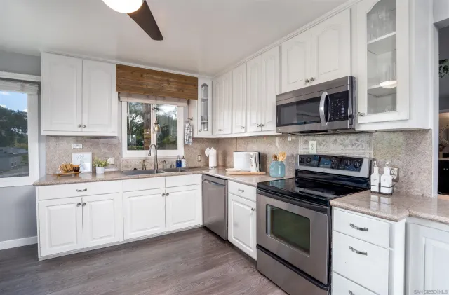 a kitchen with cabinets stainless steel appliances a sink and a microwave