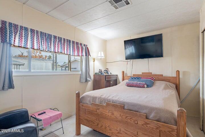 201 South Greenfield Road, Unit 142 Mesa, AZ 85206 - Photo 33 of 53 a bedroom with a bed and flat screen tv