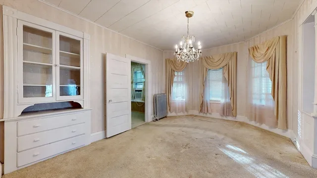 a view of a hallway with closet and chandelier