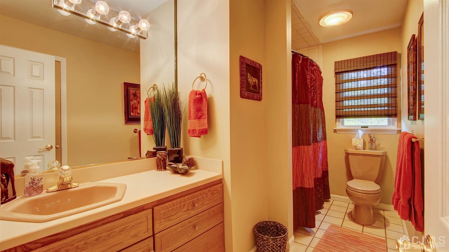 9 Tremblay Road East Brunswick, NJ 08816 - Photo 15 of 25 a bathroom with a granite countertop sink a toilet and a mirror
