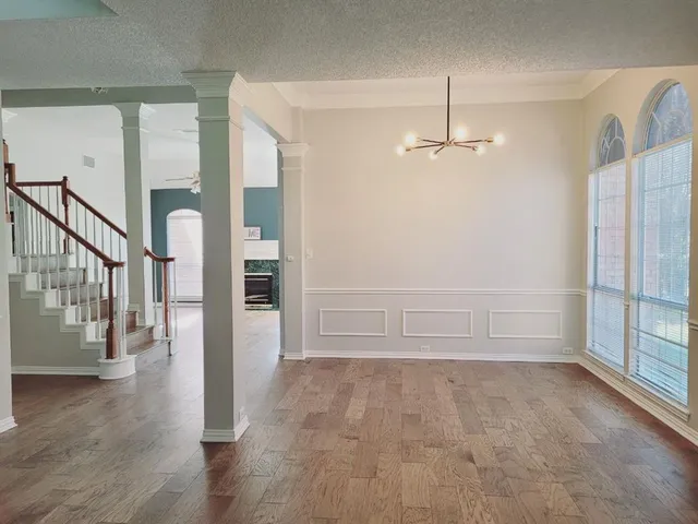 an empty room with windows and fireplace