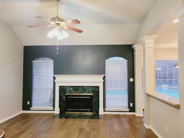 an empty room with kitchen and fireplace