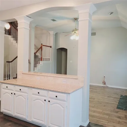 a kitchen with a sink dishwasher a refrigerator a stove and white cabinets with wooden floor