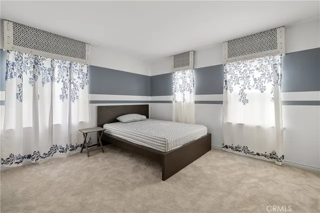 a bedroom with a bed lamp and window