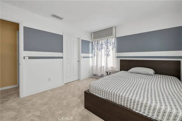 a bedroom with a large bed and a chandelier