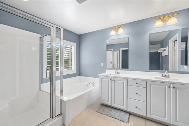 a spacious bathroom with a tub sink and mirror