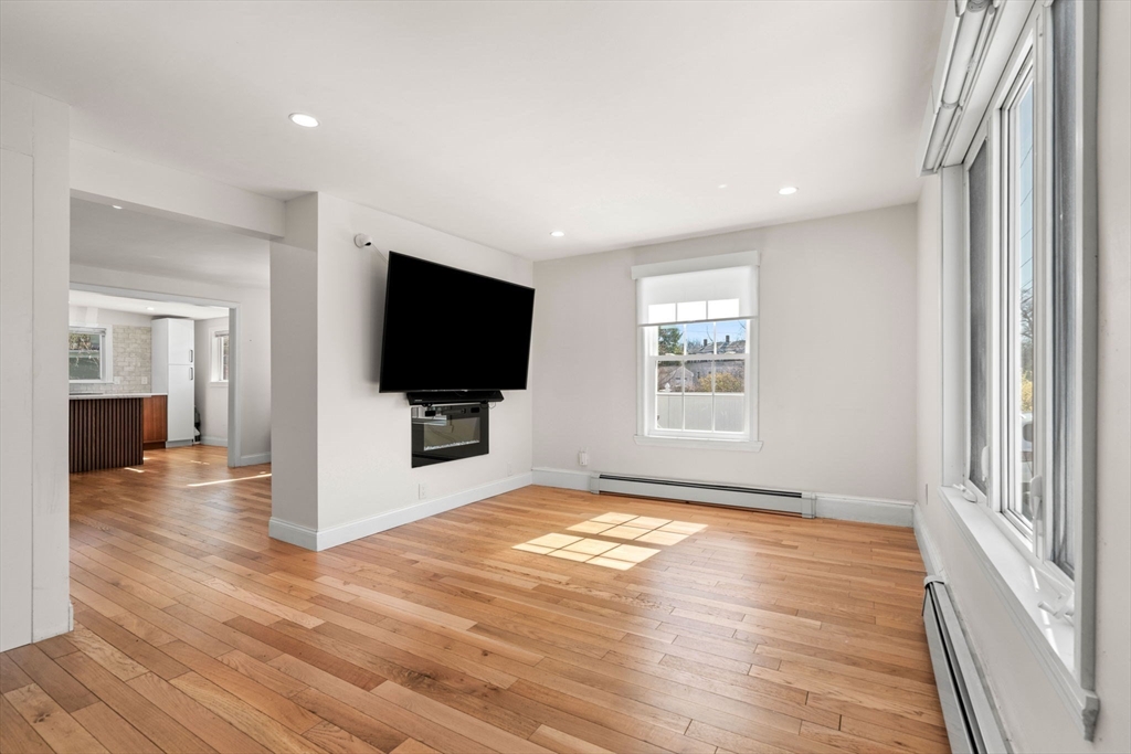 271 Broadway Haverhill, MA 01832 - Photo 7 of 41 a view of a livingroom with wooden floor and a flat screen tv