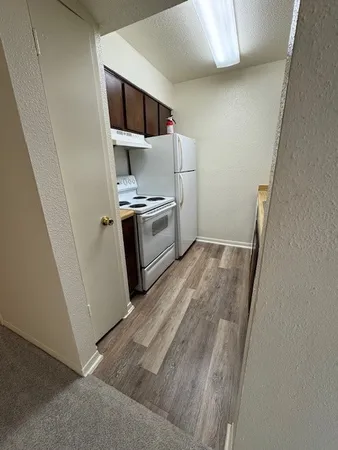 a kitchen with a refrigerator and cabinets