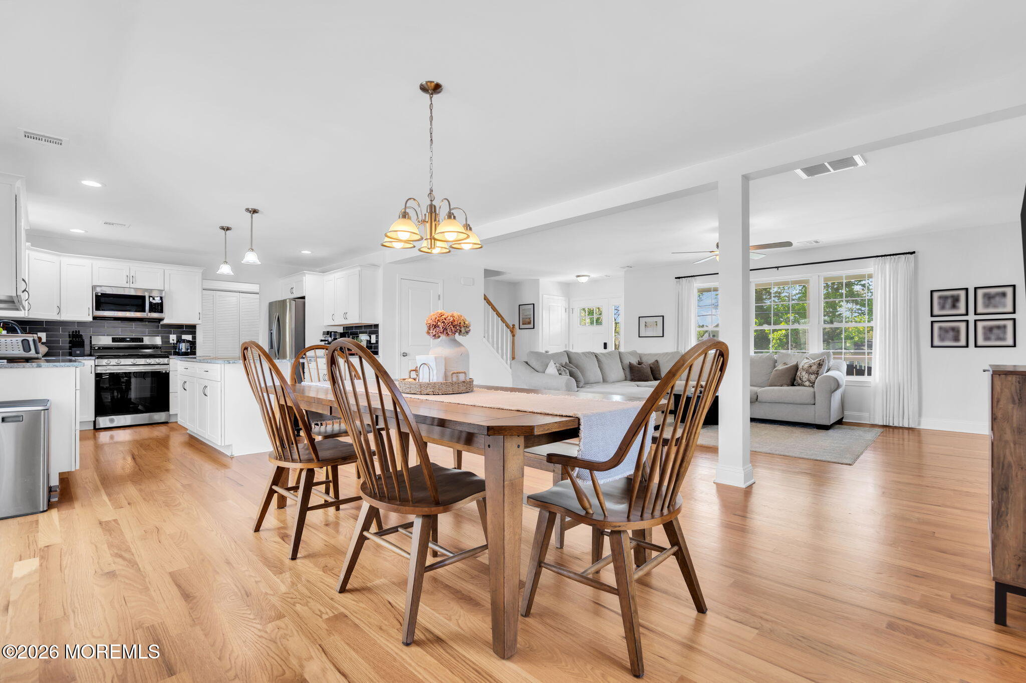 312 Beach Boulevard Forked River, NJ 08731 - Photo 15 of 40 a view of a dining room and livingroom with furniture wooden floor a chandelier