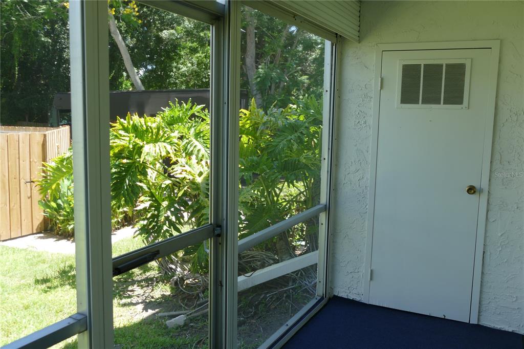 205 South McMullen Booth Road, Unit 203 Clearwater, FL 33759 - Photo 4 of 21 a view of a glass door with a tree in the yard