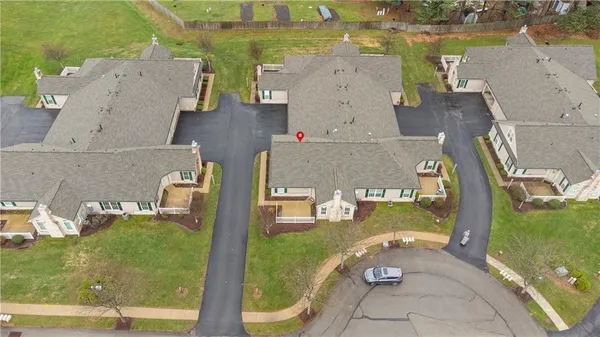 an aerial view of residential houses with outdoor space and lake view