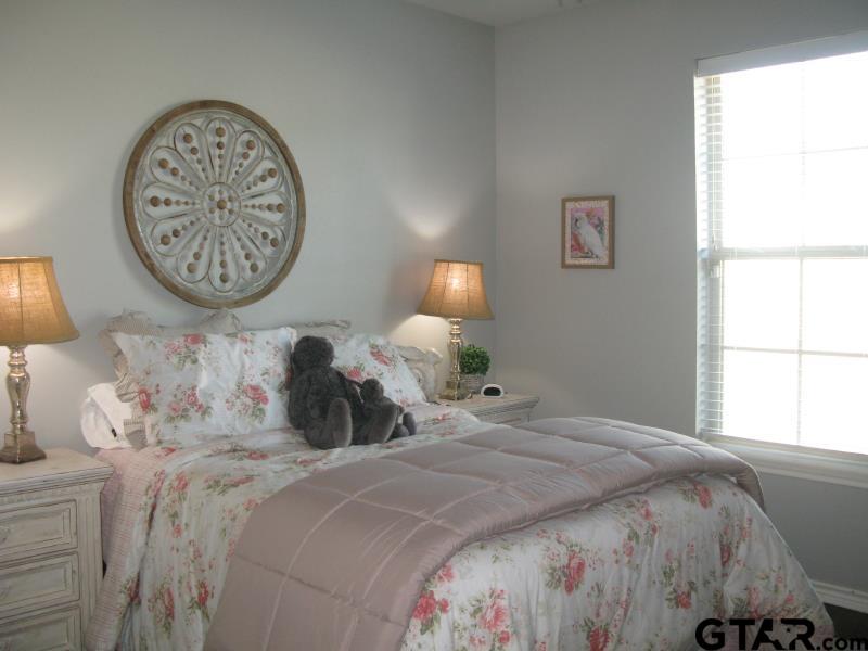 118 Nathan Road Chandler, TX 75758 - Photo 22 of 28 a bedroom with a bed and a lamp on dresser next to a window