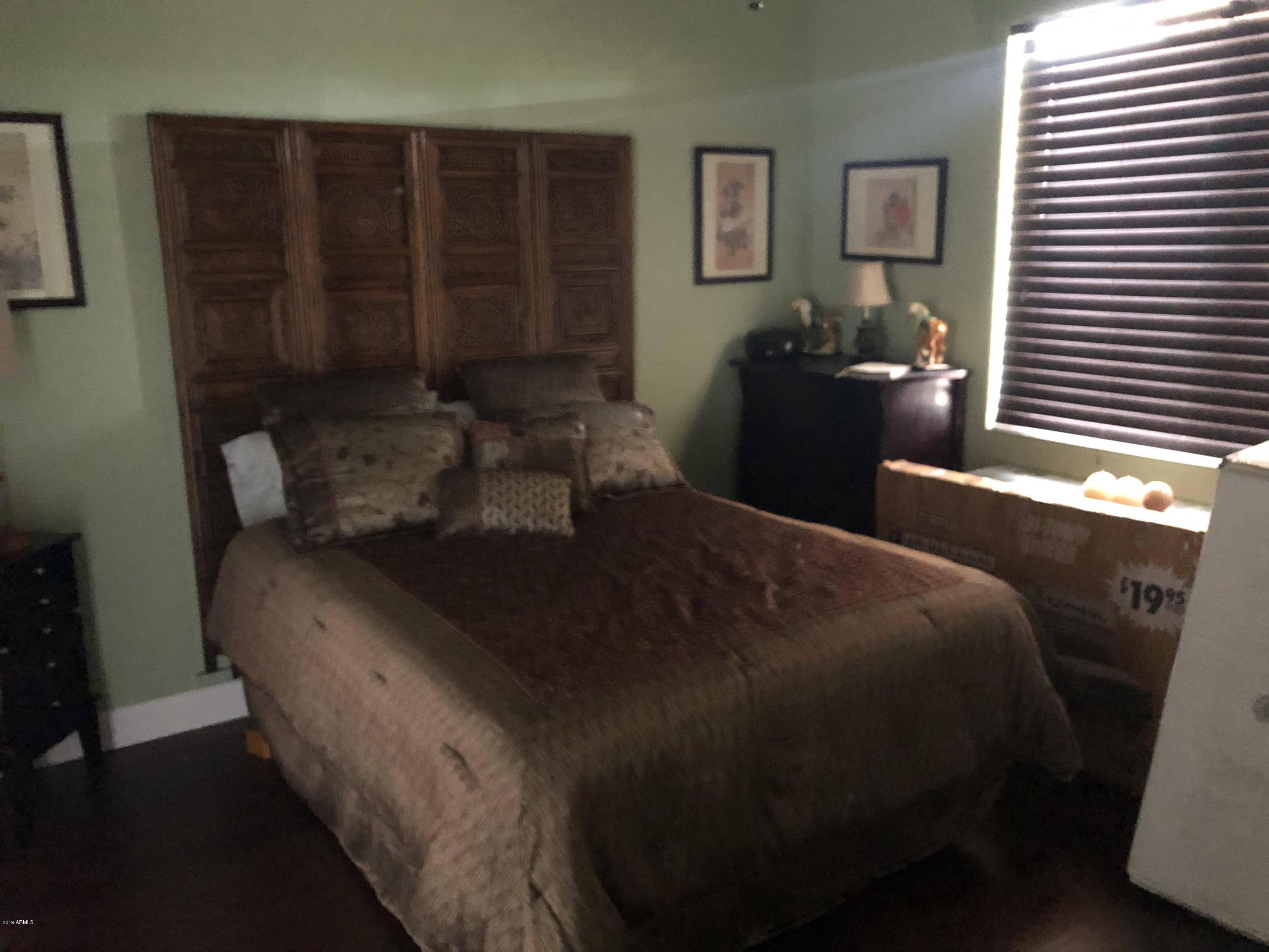 18120 West Ruth Avenue Waddell, AZ 85355 - Photo 17 of 21 a bedroom with a bed and wooden floor