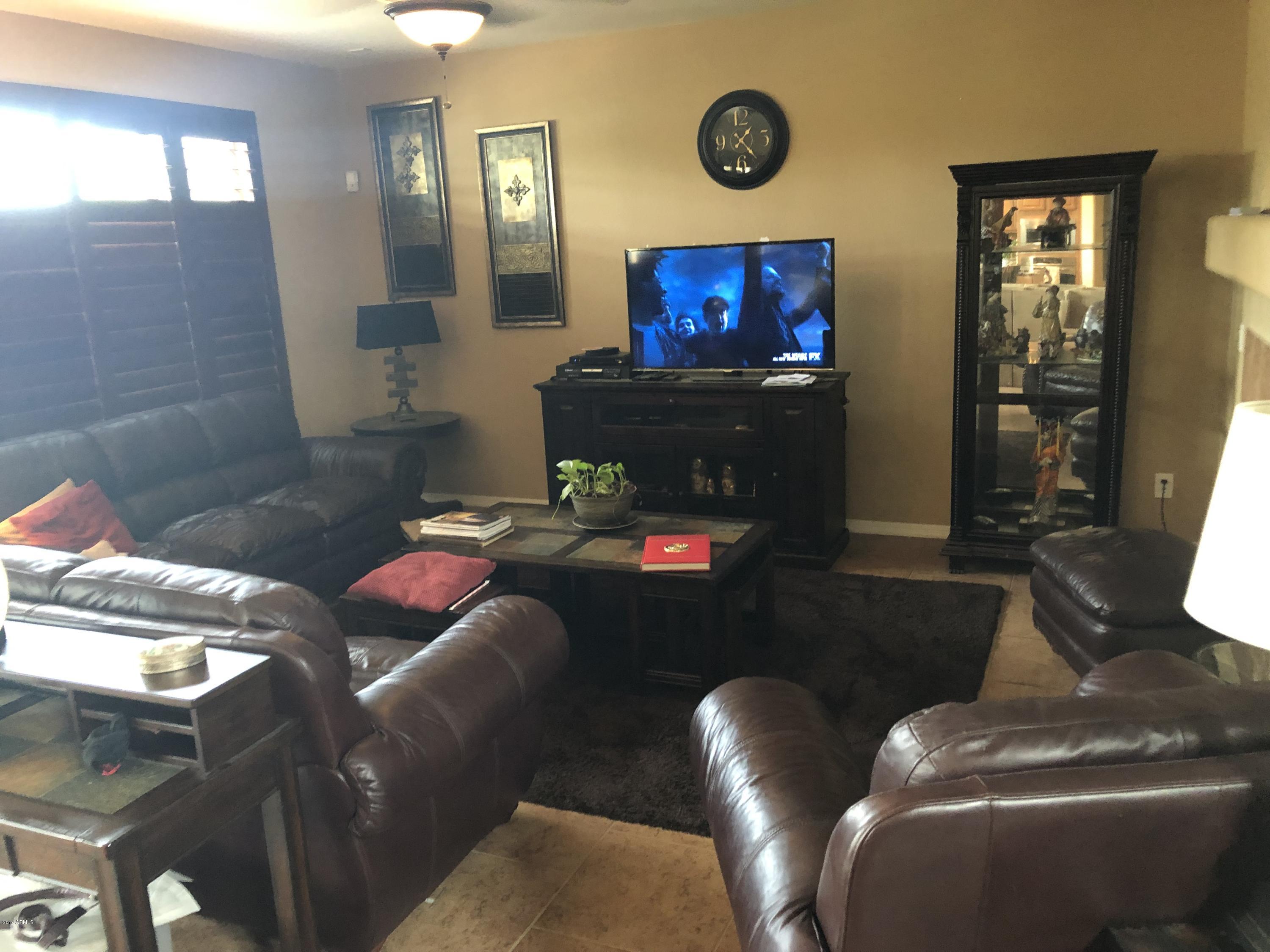 18120 West Ruth Avenue Waddell, AZ 85355 - Photo 18 of 21 a living room with furniture and a flat screen tv