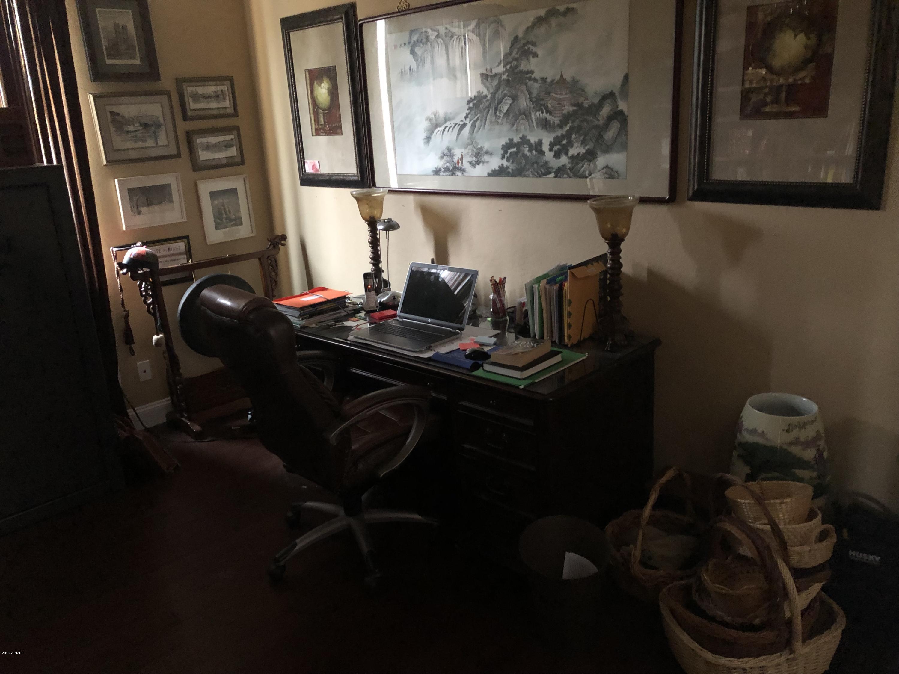 18120 West Ruth Avenue Waddell, AZ 85355 - Photo 19 of 21 a table with wine bottles and a chair in it