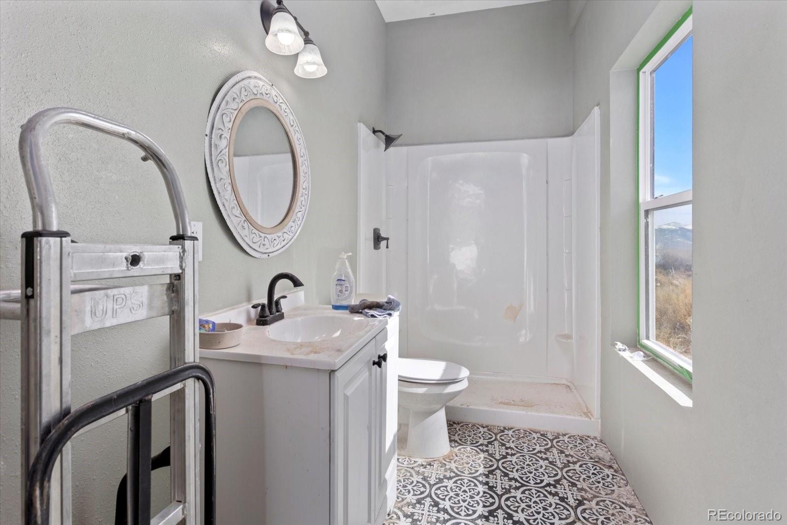 51624 Co Road Villa Grove, CO 81155 - Photo 35 of 50 a bathroom with a granite countertop sink toilet a mirror and shower