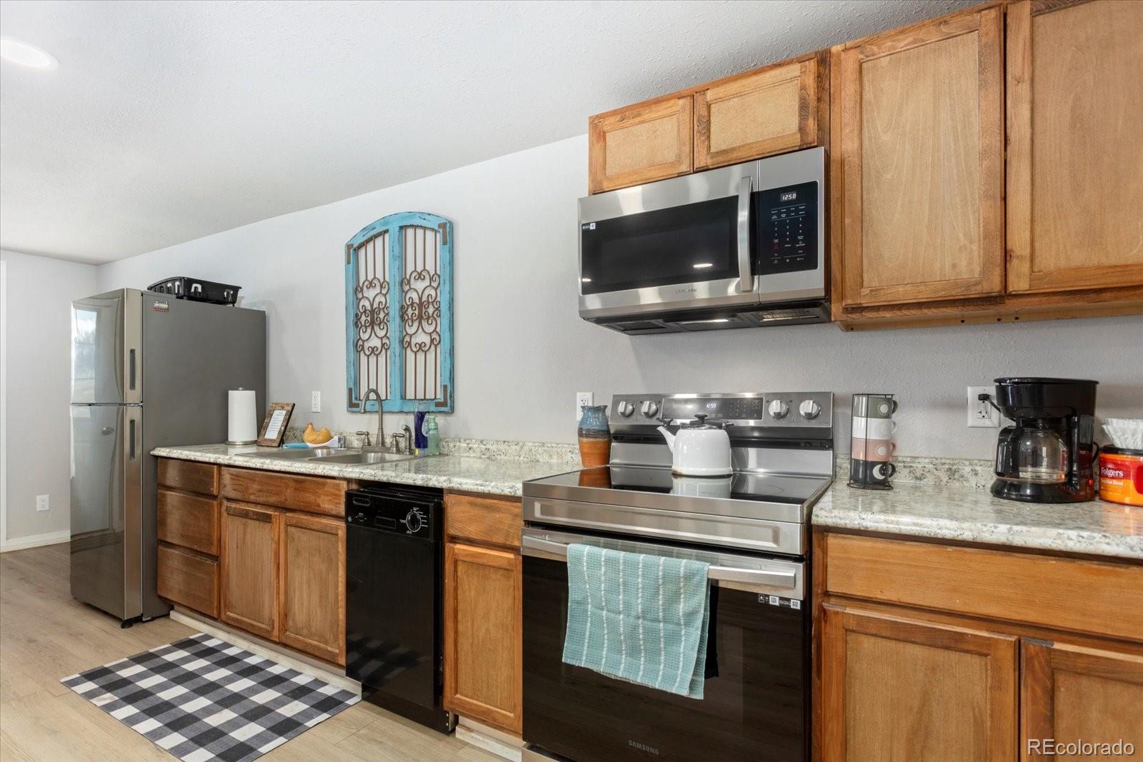 51624 Co Road Villa Grove, CO 81155 - Photo 42 of 50 a kitchen with stainless steel appliances granite countertop a sink stove and microwave