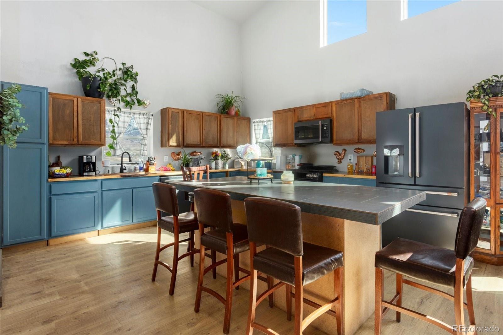 51624 Co Road Villa Grove, CO 81155 - Photo 9 of 50 a kitchen with stainless steel appliances granite countertop a stove top oven a sink a refrigerator and chairs