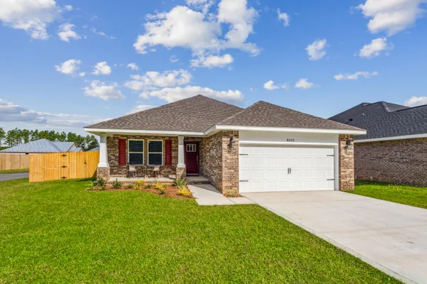 a front view of a house with a garden and yard