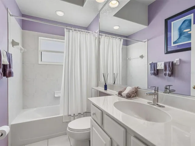 a bathroom with a granite countertop sink a toilet and shower