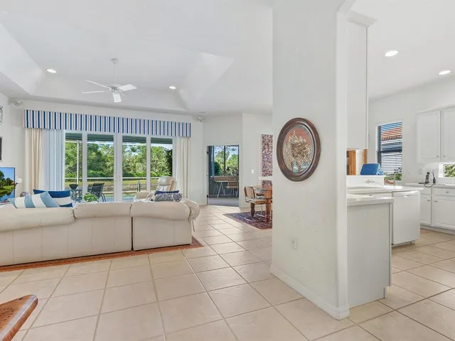 a living room with furniture a clock and a large window
