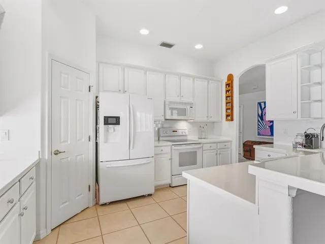 a kitchen with white cabinets and white appliances