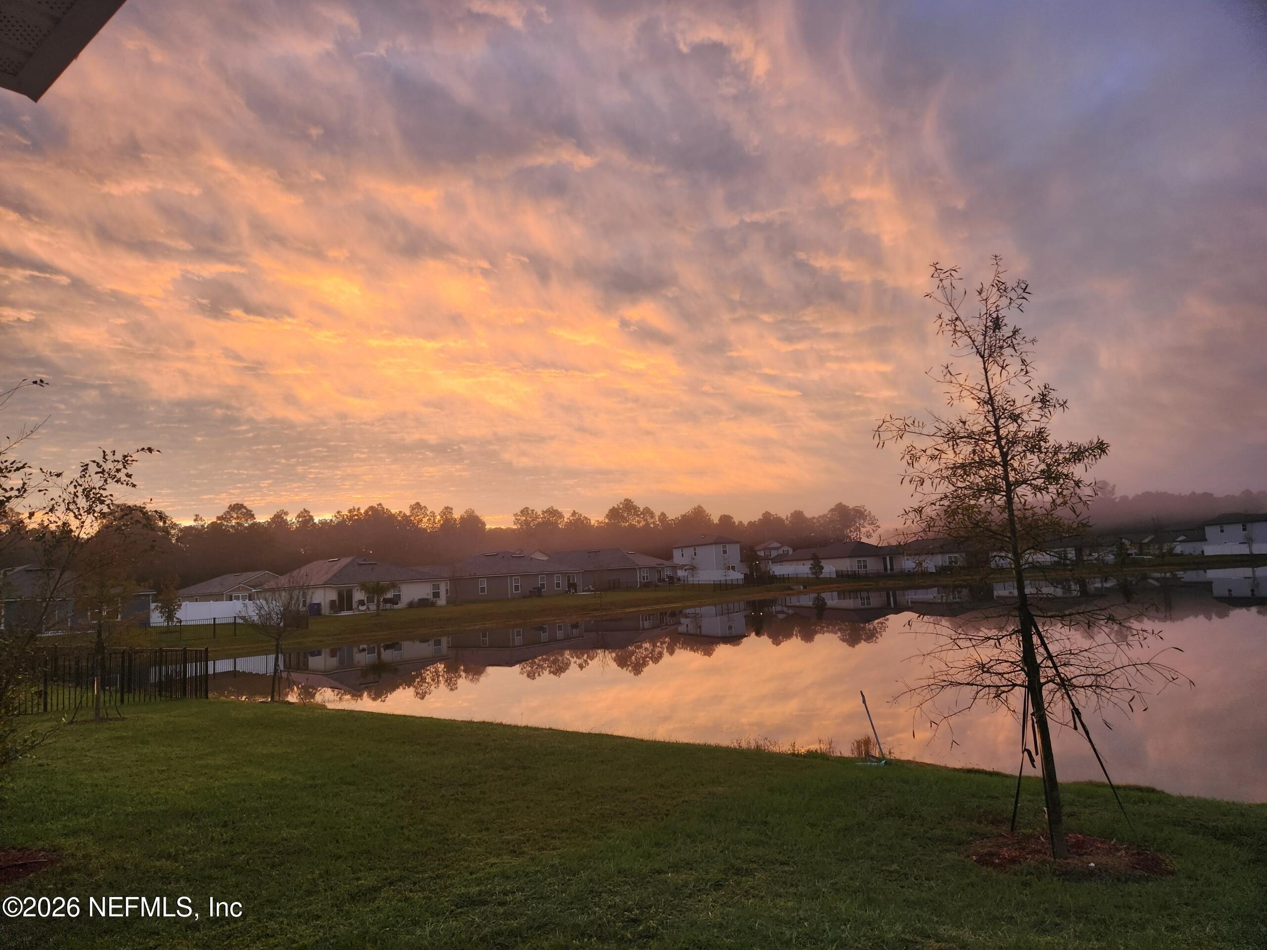 233 Falcon Ridge Road St. Augustine, FL 32084 - Photo 25 of 34 a view of a lake with houses in the back
