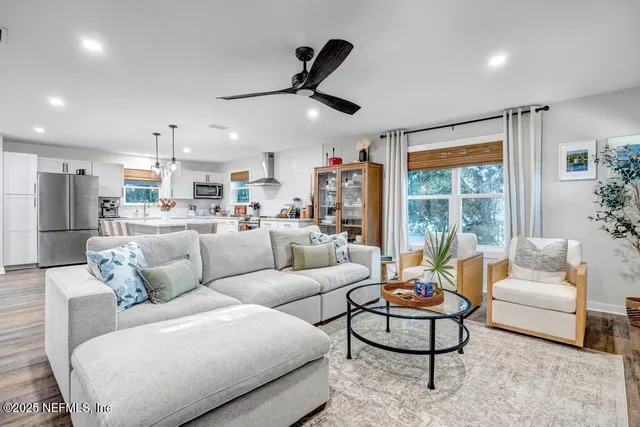 a living room with furniture kitchen view and a potted plant