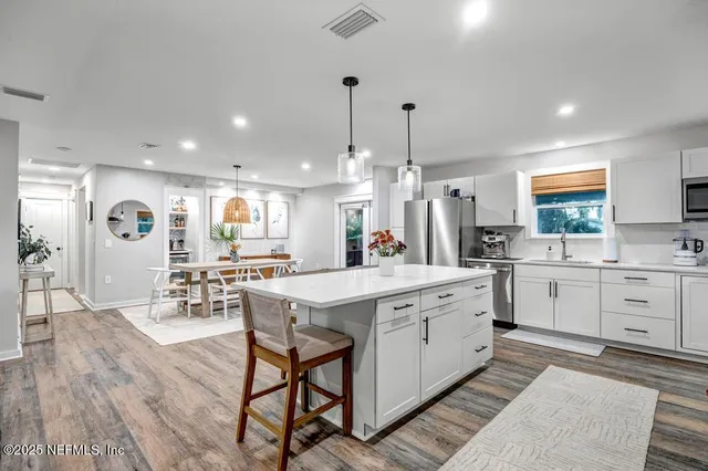 a kitchen with stainless steel appliances a sink stove refrigerator and cabinets