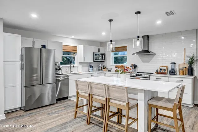 a kitchen with a table chairs sink and cabinets