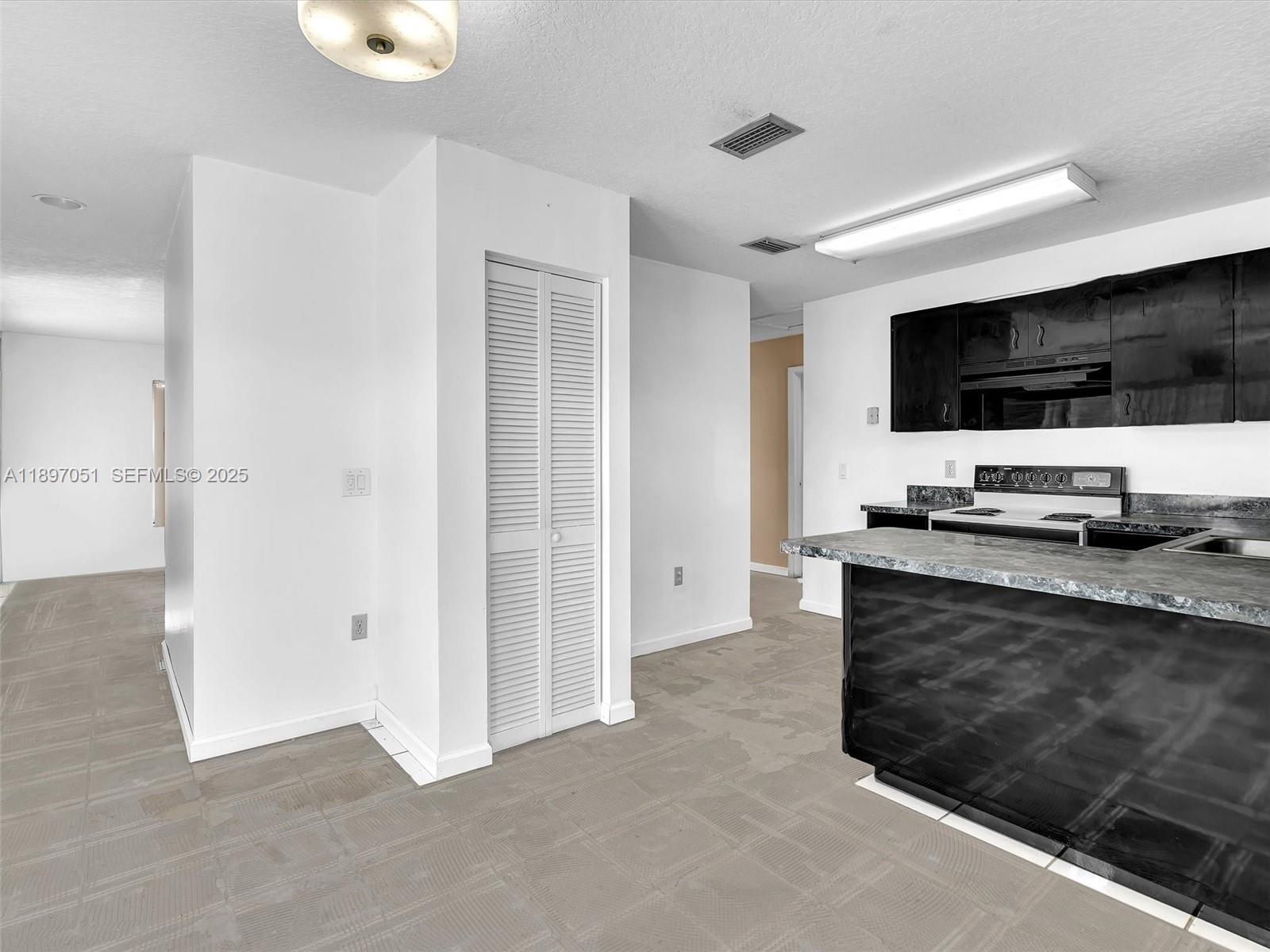 17995 Southwest 105th Avenue Miami, FL 33157 - Photo 31 of 45 a living room with stainless steel appliances kitchen island granite countertop a refrigerator and a stove top oven