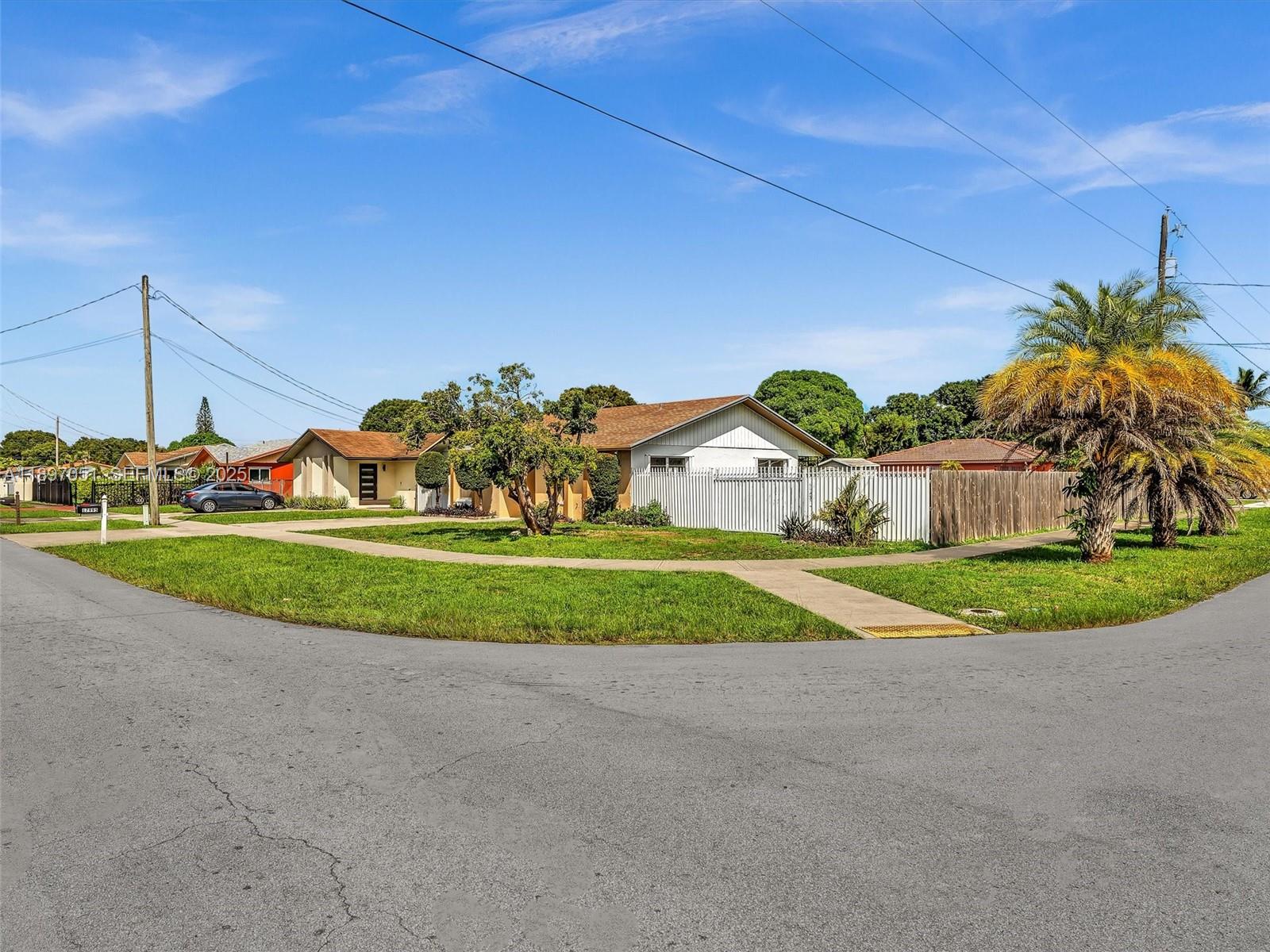 17995 Southwest 105th Avenue Miami, FL 33157 - Photo 44 of 45 a view of a house with a big yard and palm trees