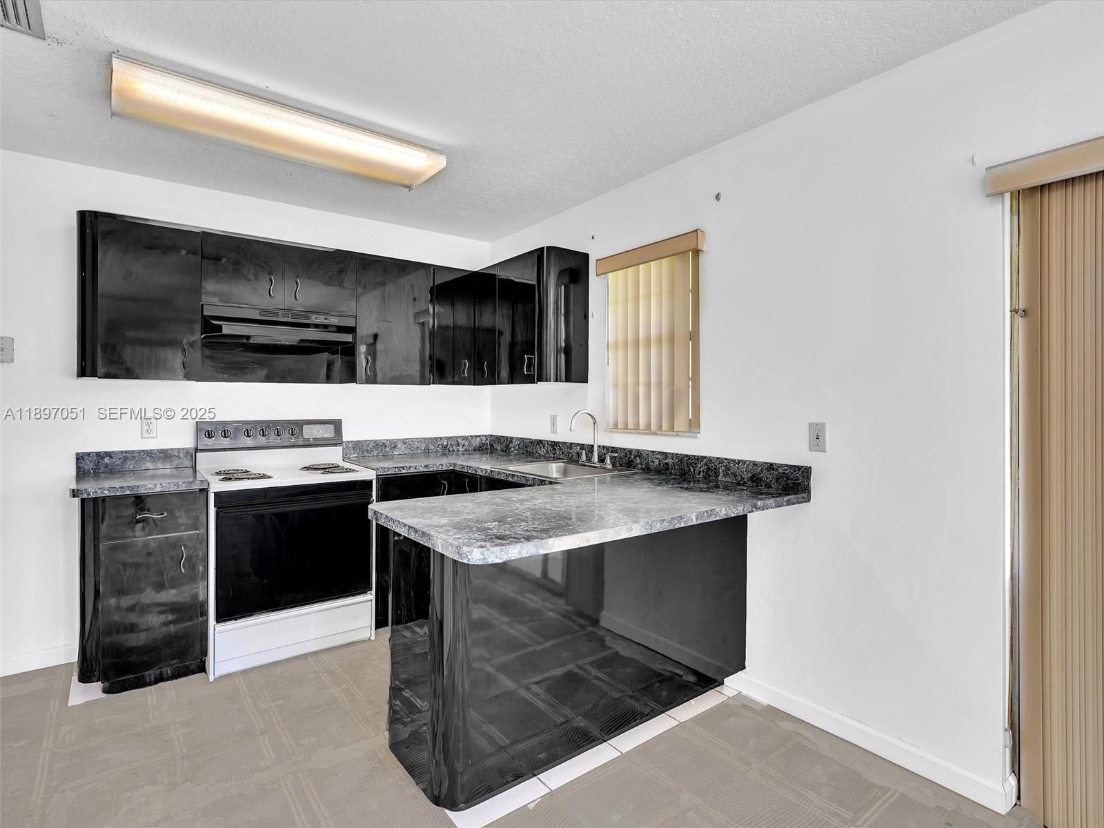 17995 Southwest 105th Avenue Miami, FL 33157 - Photo 6 of 45 a kitchen with stainless steel appliances a stove microwave and refrigerator