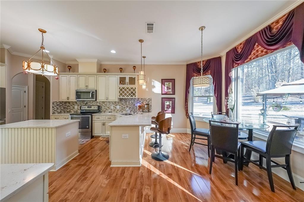 2425 Wild Oak Court Stockbridge, GA 30281 - Photo 13 of 32 a kitchen with stainless steel appliances a dining table chairs stove and kitchen view