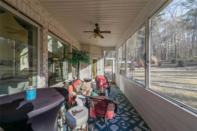 a view of a patio with table and chairs potted plants with floor to ceiling window