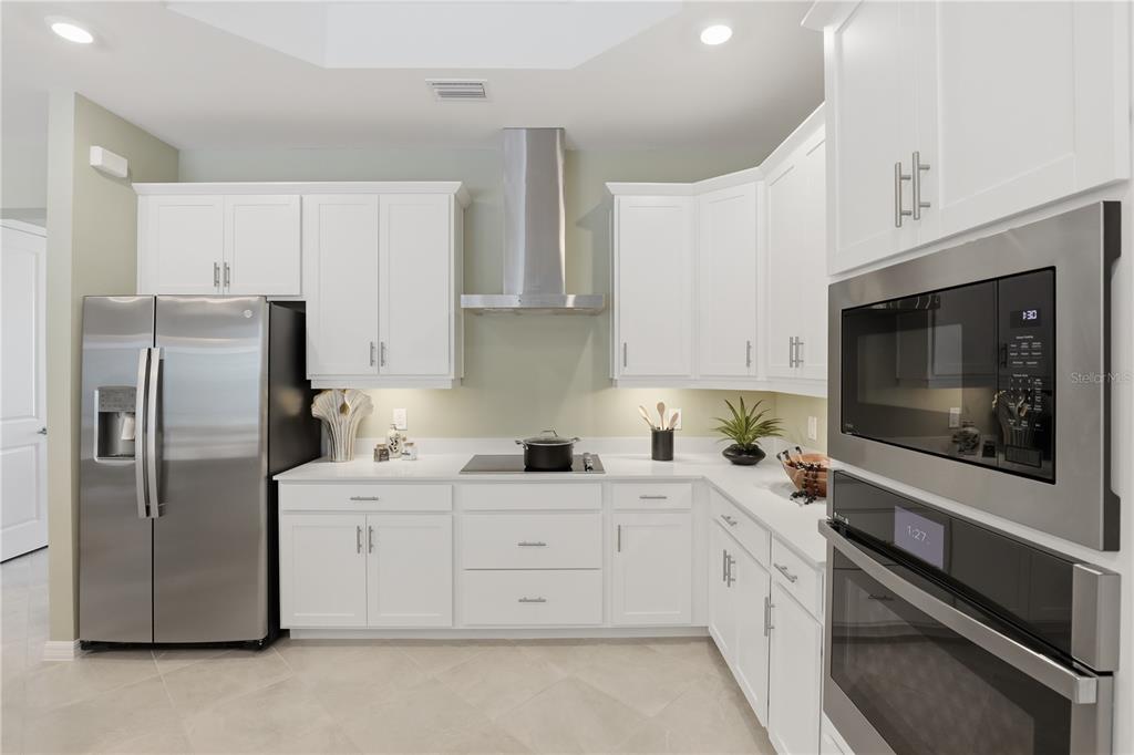 7153 Inlet Isles Lakewood Ranch, FL 34202 - Photo 10 of 26 a kitchen with white cabinets stainless steel appliances and sink
