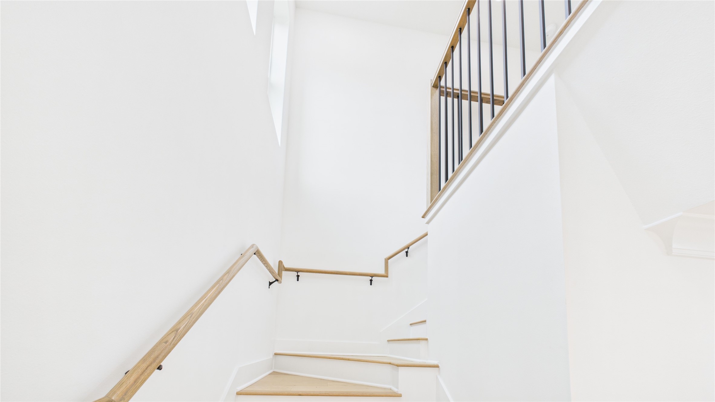 602 Jewett Street, Unit A Houston, TX 77009 - Photo 18 of 46 Bright, modern staircase with light wood steps and sleek metal railing, offering a clean and airy feel.