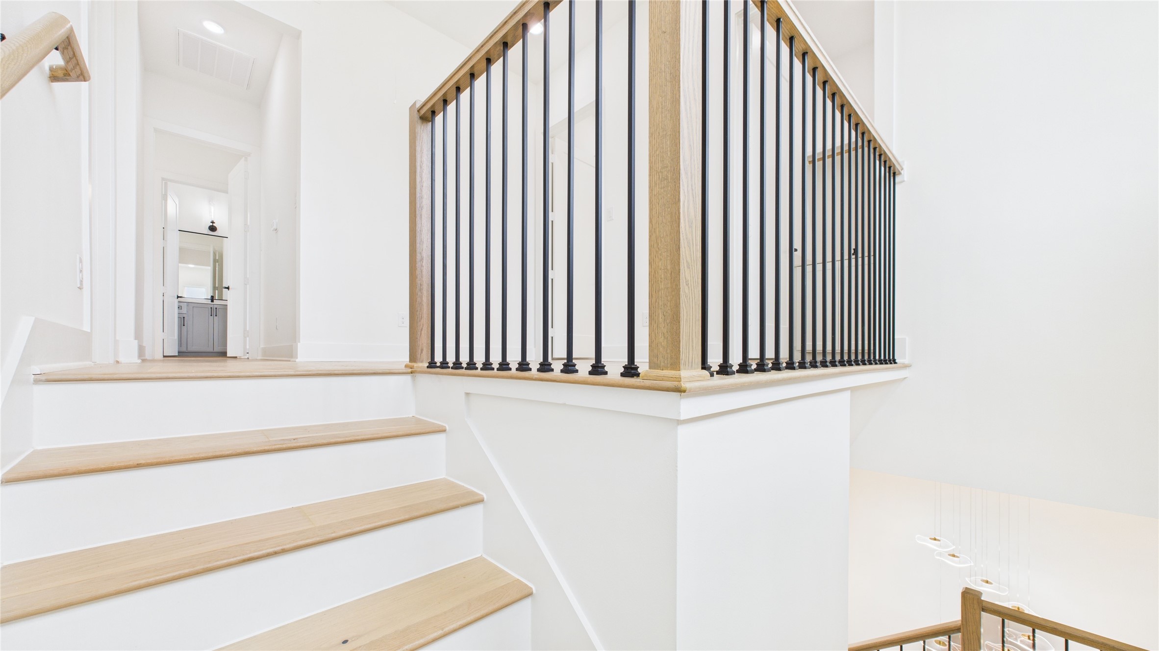 602 Jewett Street, Unit A Houston, TX 77009 - Photo 19 of 46 The open design leads to an upper landing with a glimpse into a hallway and a well-lit room in the background, creating an inviting and spacious feel.