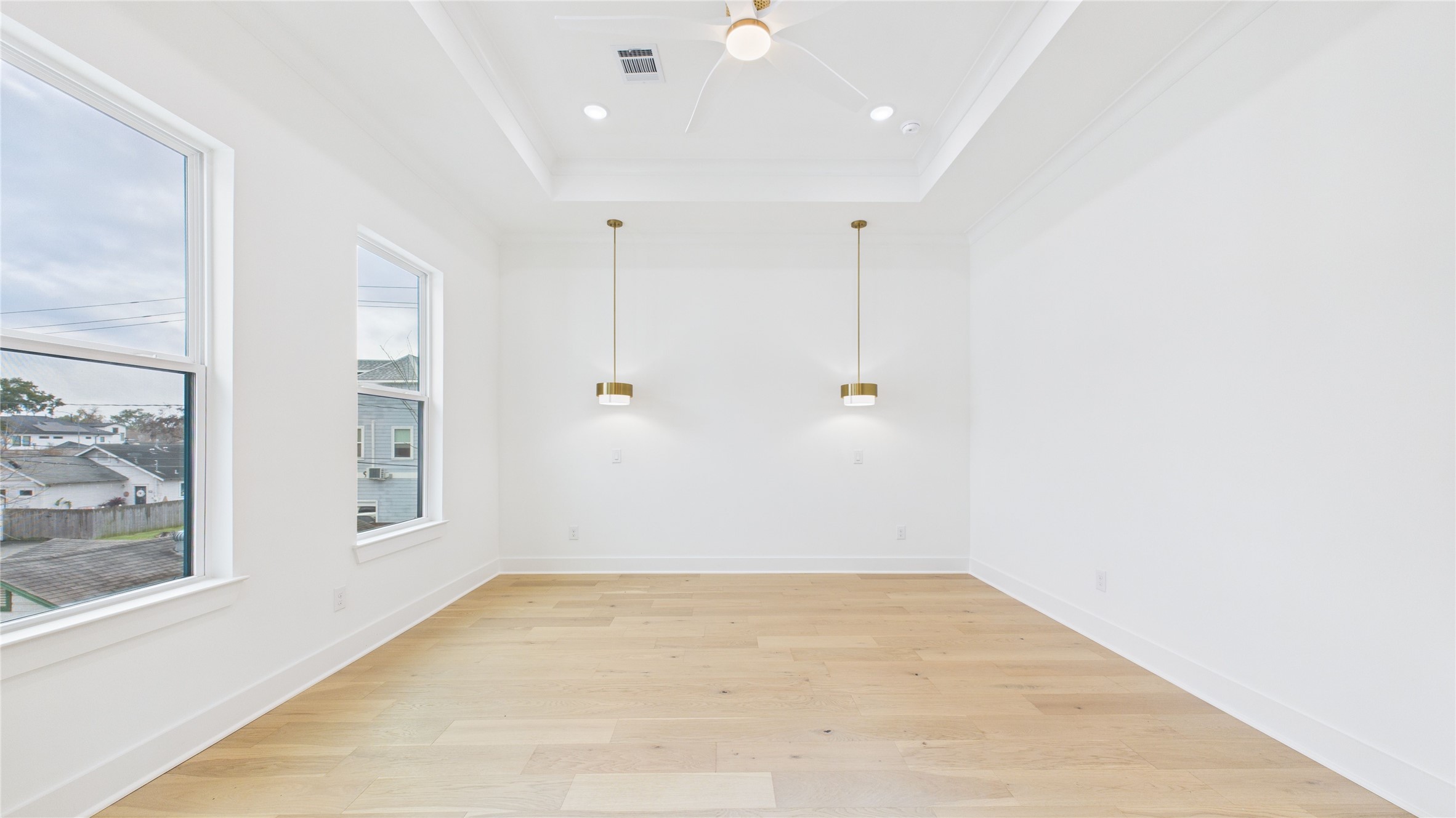 602 Jewett Street, Unit A Houston, TX 77009 - Photo 26 of 46 This bright, open room features large windows for natural light, light wood flooring, and modern pendant lighting, creating a welcoming and spacious atmosphere.