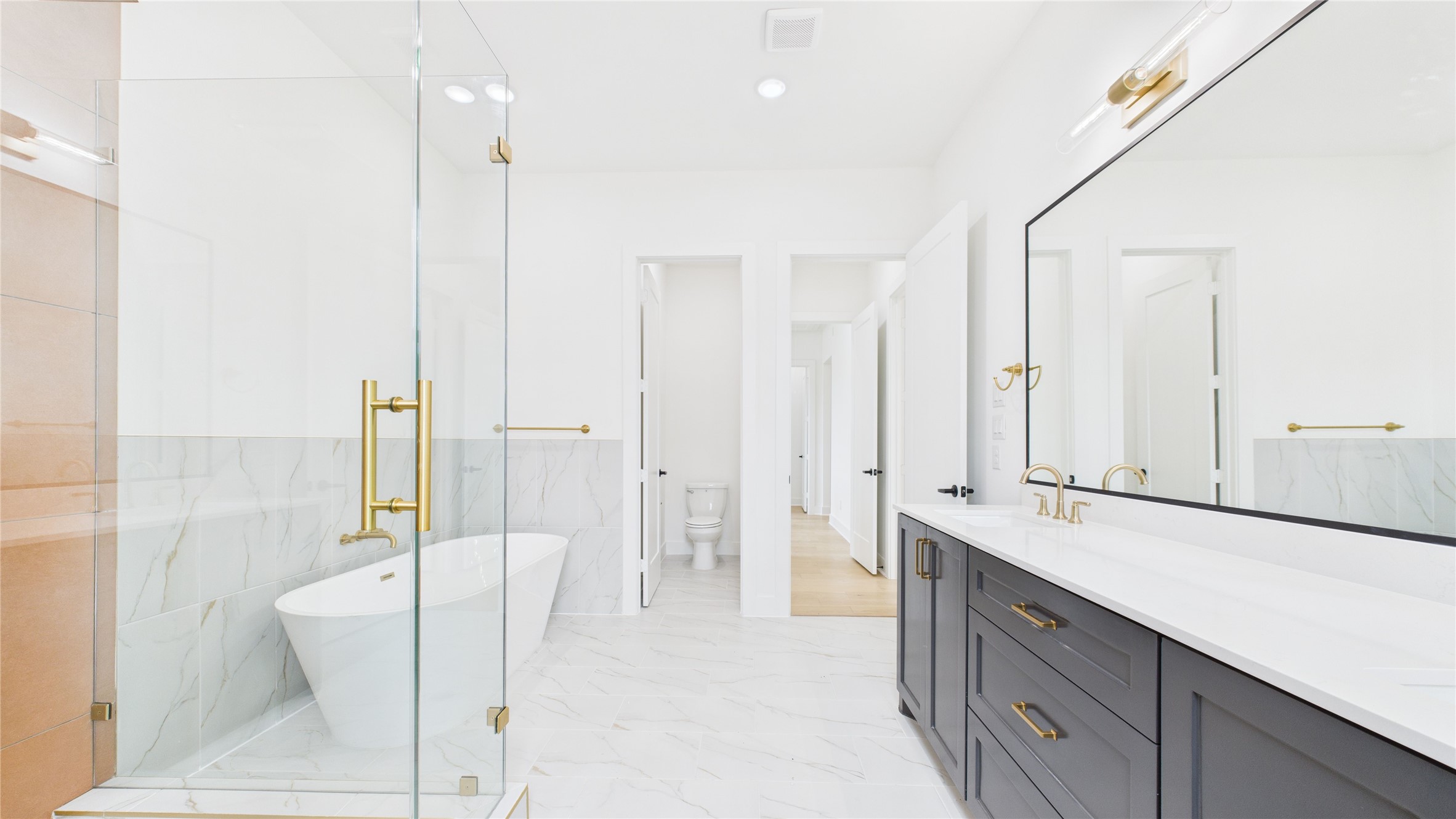 602 Jewett Street, Unit A Houston, TX 77009 - Photo 29 of 46 The double vanity has ample storage with sleek black cabinetry and gold fixtures, creating a luxurious feel.