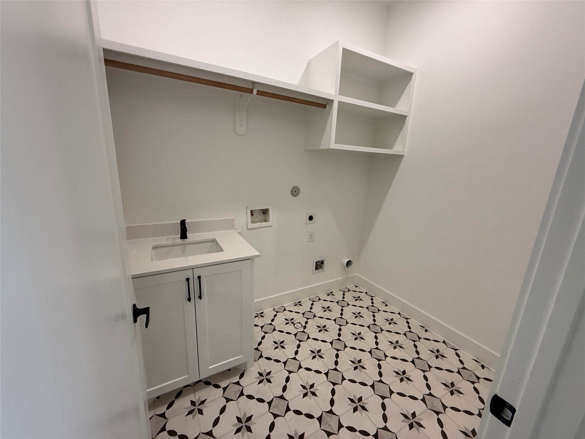 602 Jewett Street, Unit A Houston, TX 77009 - Photo 43 of 46 The second floor utility room features cabinetry, open shelving, and a patterned tile floor. It includes a space for a washer, dryer and sink with ample storage.