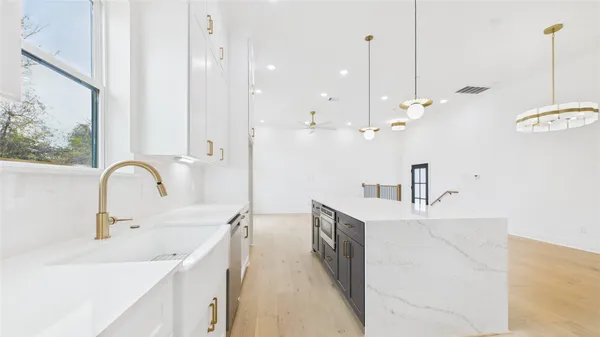 a kitchen with kitchen island a sink appliances and a counter top space