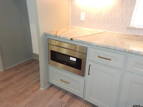 a kitchen with granite countertop white cabinets and stainless steel appliances